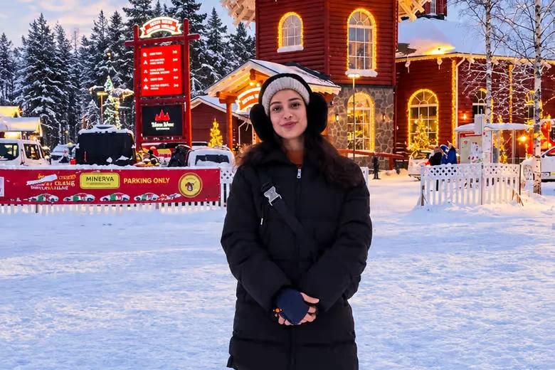 Visitor outside the festive buildings at Santa Claus Village