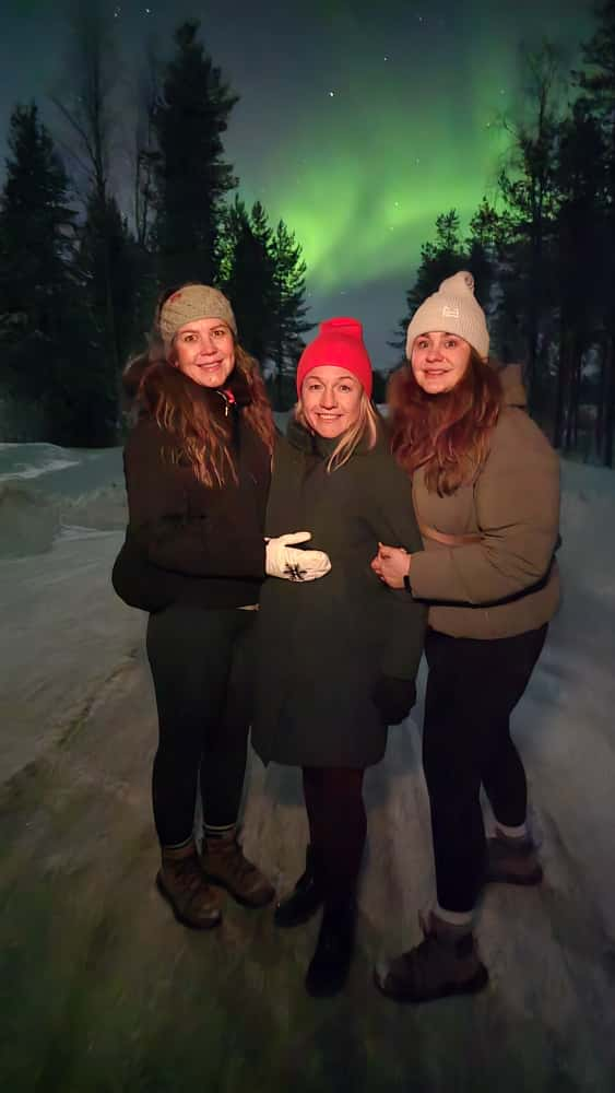 Northern Lights and travellers in Lapland