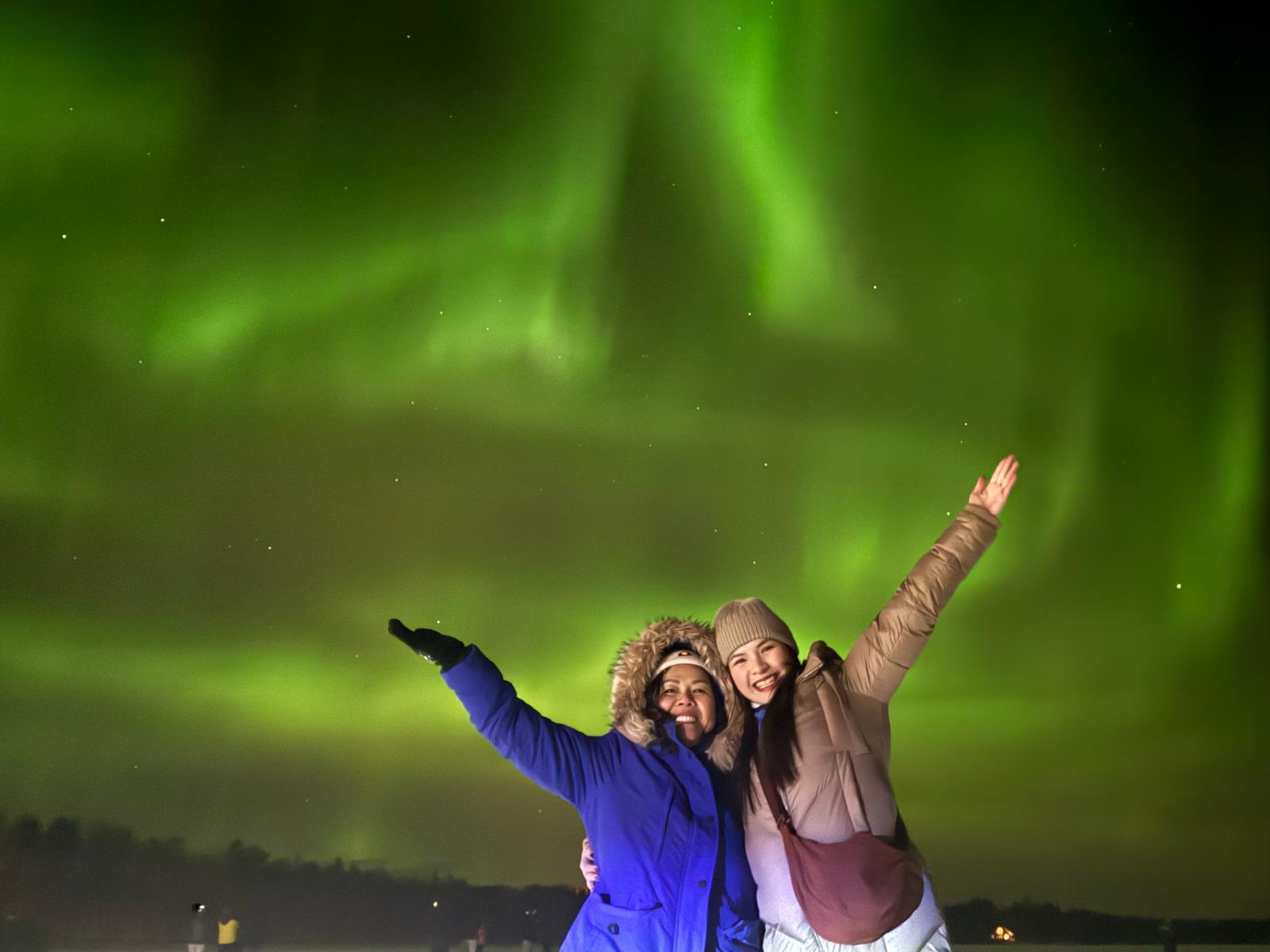 Northern Lights and travellers in Lapland